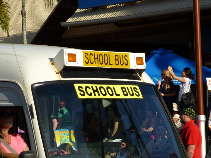 Front windscreen and yellow sign on a school bus with students visible in the background and in the bus