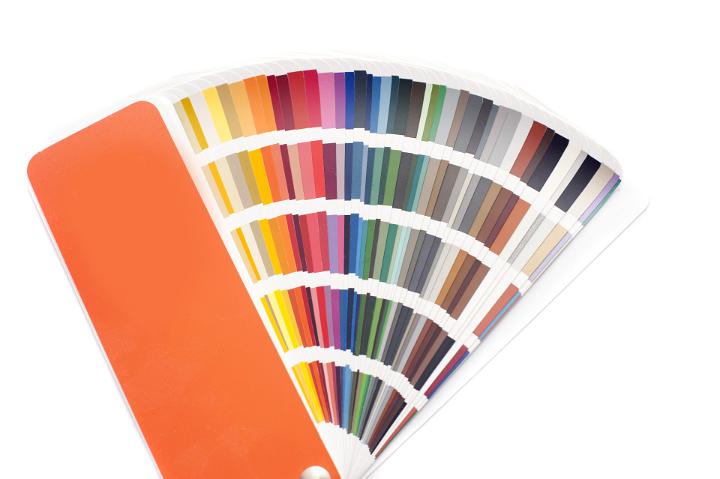 Fanned color swatches or cards with a spectrum of color to mix and match hues of fabrics and paints in interior decorating, on white