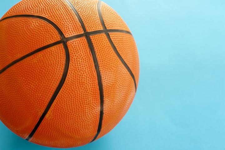 Close up One Orange Basketball Ball Isolated on Sky Blue Background with Copy Space for Texts