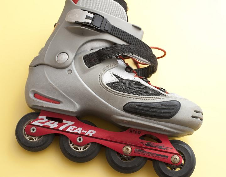 Single Unlaced In Line Skate Lying on Side on Yellow Background