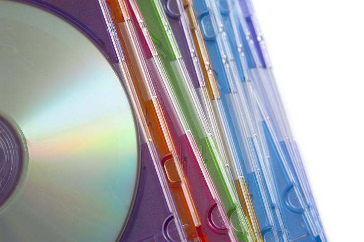 Overhead Image of Stack of Compact Disks in Colorful Jewel Cases on White Background