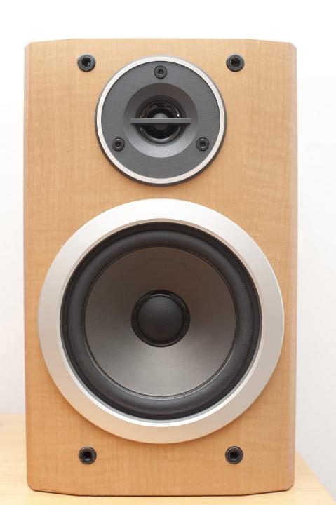 Plain brown speaker box with exposed speakers for sound and music broadcasting and entertainment over a white background
