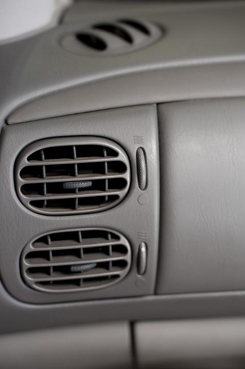 Close up of two adjustable air vents on a car dashboard for air flow when using the air conditioner or heater, or for fresh air from the exterior