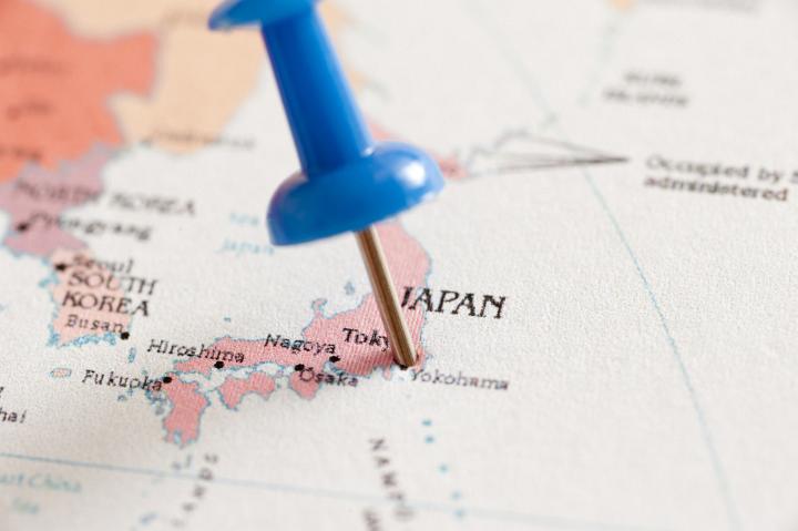Close Up of Blue Pin Inserted into Map of Japan Pin Pointing Location of Tokyo