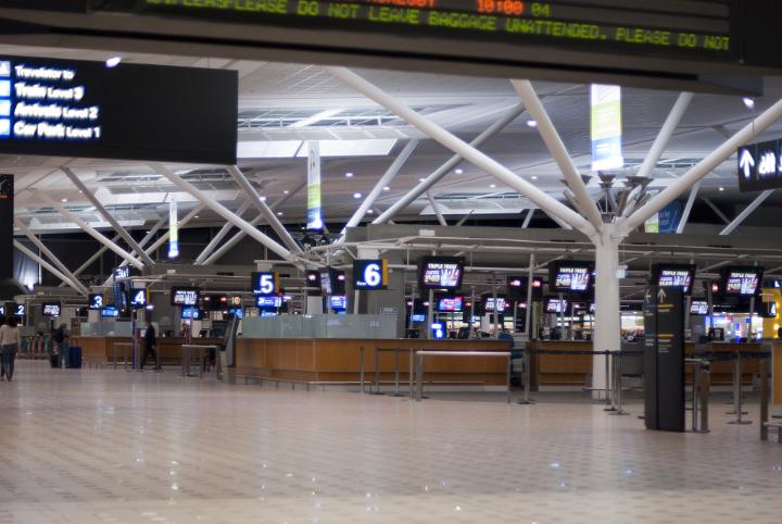 Quiet airport terminal with a view of the check in counters in the main hall of the terminal viewed from a distance in a travel and vacation concept